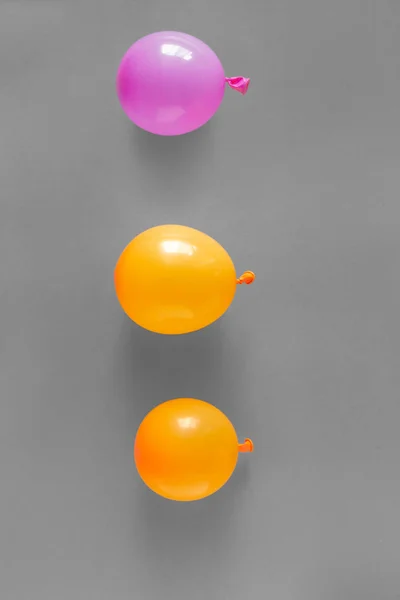 Orange and purple balloons in gray background