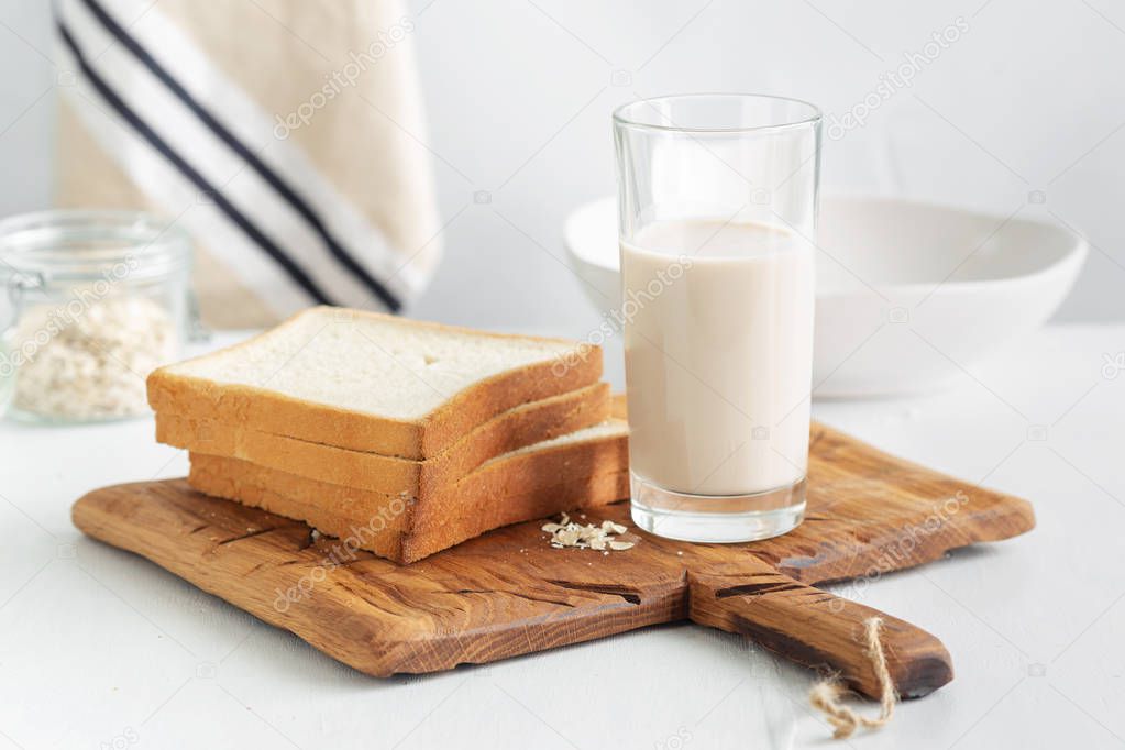 Brunch or breakfast table. Oat milk with bread toasts on wooden table. Healthy breakfast concept