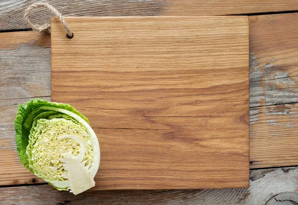 Oak cutting board handmade with cabbage on wooden kitchen table top view