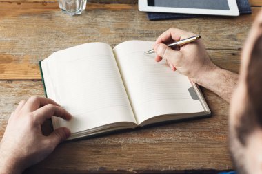 Adam ev ofis ahşap masa üstünde belgili tanımlık defter için yazma notlar eller