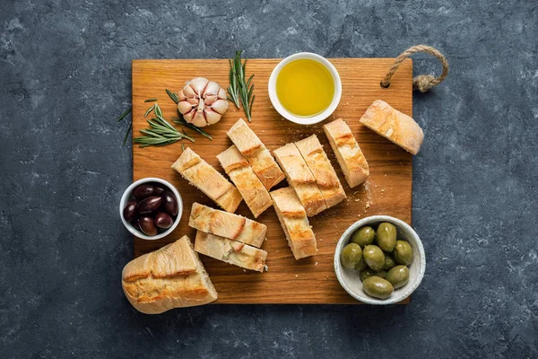 Cocina italiana Bruschetta italiana Aceitunas rodajas de baguette frescas aceite de oliva romero de ajo — Foto de Stock