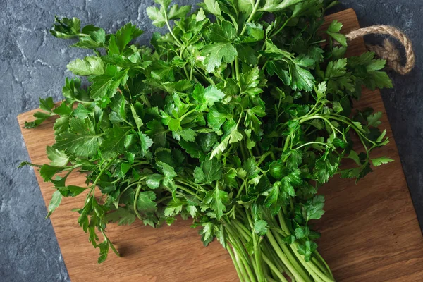 Bunch parsley dark stone background top view — Stock Photo, Image