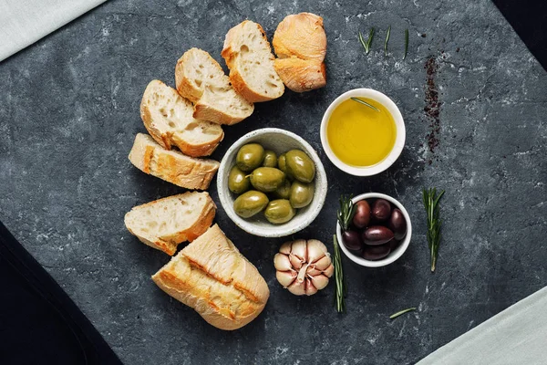 Italiaans eten koken Italiaanse bruschetta olijven vers stokbrood segmenten olijfolie knoflook-rozemarijn — Stockfoto