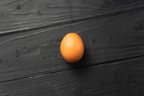 1 つの鶏の卵暗い背景の木トップ ビュー — ストック写真