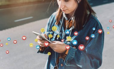 Genç kadın şehir caddesinde yürürken canlı yayın izliyor.