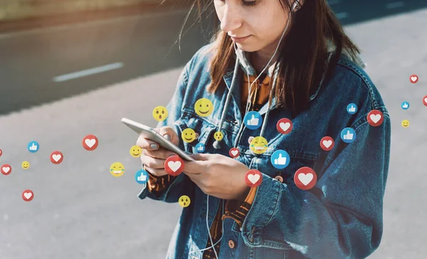 Genç kadın şehir caddesinde yürürken canlı yayın izliyor.