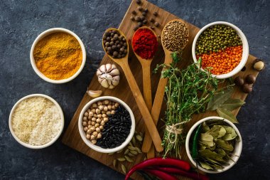 Baharatlar ve otlar, pirinç ve koyu arka plan üst görünümünde çeşitli fasulye