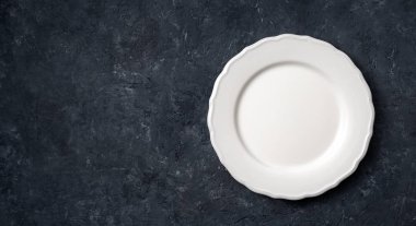 Koyu taş zemin üzerinde beyaz eski seramik tabak