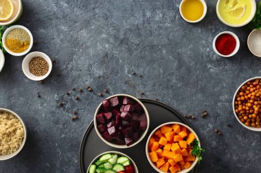Sağlıklı vejetaryen yemek pişirmek için yemek ayarlayın. Baharatlı nohut, pişmiş kabak ve pancar, kinoa ve sebze koyu taş arka plan üzerinde kopya alanı üst görünümü ile