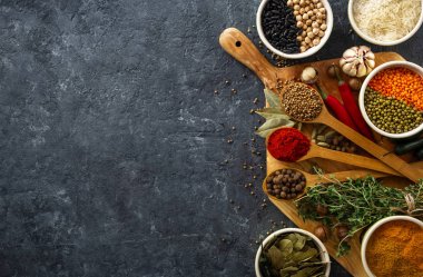 Baharatlar, otlar, pirinç ve çeşitli fasulye ve baharatlar kopya alanı üst görünümü ile koyu backgraund üzerinde yemek için