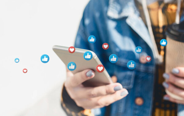 Young woman using social media on their smartphon walking down c