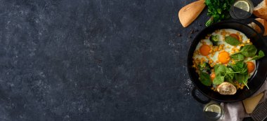 Kopya alanı ile koyu taş arka plan üzerinde kızarmış yumurta ıspanak ve mısır üst görünümü ile aile kahvaltı masası