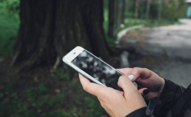 El ele tutuşan cep telefonu yakın. Akıllı telefonda mesajlaşma kadın elleri