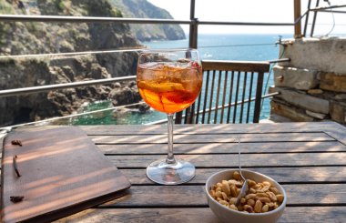 Aperol spritz kokteyl yakın bir restoranda ahşap bir masa üzerinde. Riomaggiore in Cinque Terre, İtalya