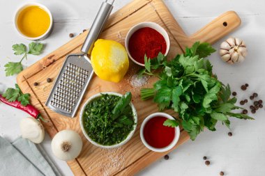 Üst görünüm pişirme arka plan. Beyaz ahşap masada yeşil Chimichurri veya Chimmichurri salsa veya sos pişirmek için ham maddeler