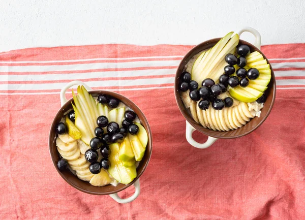白い背景の上のビューにオートミールと梨 リンゴ ブルーベリー バナナとプレート 健康的な朝食コンセプト — ストック写真