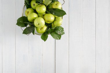 Kopya alanı üst görünümü ile ahşap bir masada kevgir taze yeşil elma