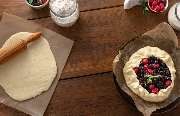木製のテーブルトップビューに生のフルーツパイ ビスケット イチゴ ブルーベリー ブラックベリー ラズベリーとタルトパイを調理するための成分 — ストック写真