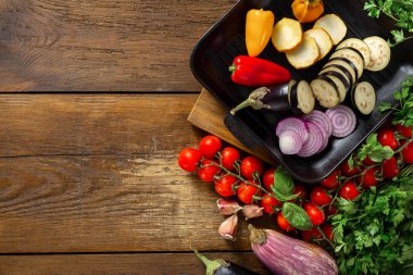 Ahşap arka planda ızgara tepsisinde pişirmek için çeşitli sebzeler kopya alanı