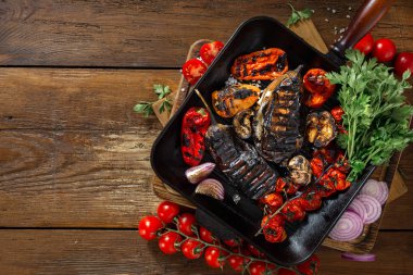 Ahşap arka planda ızgara tepsisinde pişirmek için çeşitli sebzeler kopya alanı