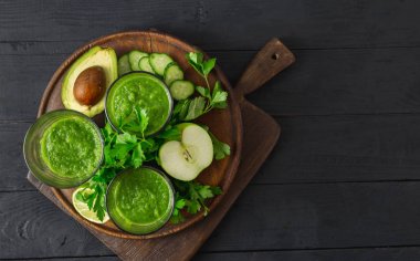 Detoks diyet konsepti. Ahşap arka plan üst görünümünde yeşil smoothie