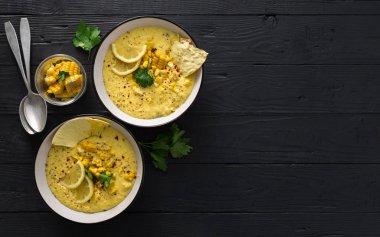 Ahşap koyu arka plan üzerinde kesme tahtası üzerinde Tatlı mısır çorbası