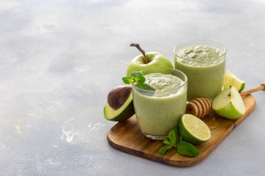 Sağlıklı temiz beslenme konsepti Elma ıspanak limon avokado ve bal kopya alanı ile bir masada kahvaltı yeşil meyve suyu yüzlü