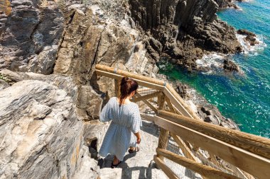 Elbiseli genç kadın Cinque Terre İtalya Romantik yürüyüş parkuru boyunca yürüyor