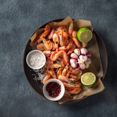 Karanlık bir arka plan üst görünümünde pişirme için malzemelerle bir Pan içinde ham karides