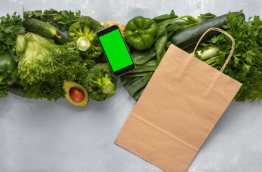 Metin mesajınız veya yeşil yeşil sebzelerle tasarım için boş ekrana sahip akıllı telefon. Cep telefonu uygulama konsepti ile gıda siparişi