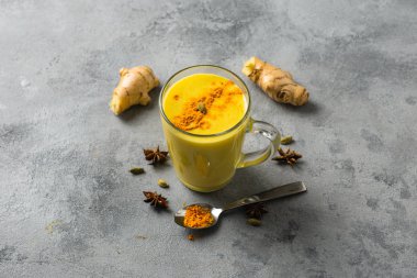 Hintliler cam içinde zerdeçal altın sütü içerler. Hafif arkaplanda altın latte, yemek malzemeleri.