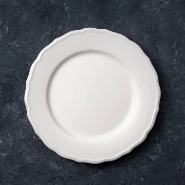 Koyu taş zemin üzerinde beyaz eski seramik tabak