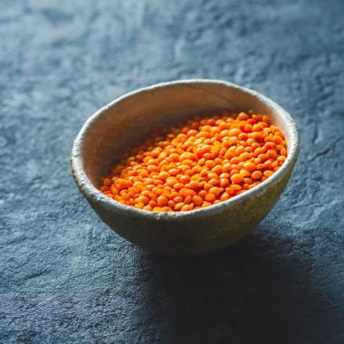 Koyu taş arka planda bir kase yakın yukarı kırmızı mercimek