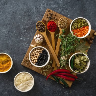 Baharatlar, otlar, pirinç ve çeşitli fasulye ve baharatlar kopya alanı üst görünümü ile koyu backgraund üzerinde yemek için