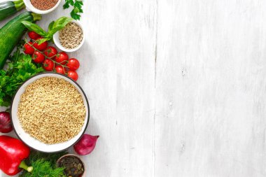 Yemek yapmak ve sağlıklı yemek yapmak için gerekli malzemeler. yeşil karabuğday, ayçiçeği ve keten tohumu, sebze ve yeşillikler ahşap beyaz arka planda fotokopi alanı ile üst görünüm