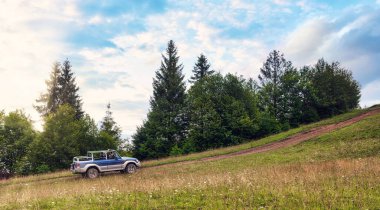 Gün batımında dağ yoluna çıkan off-road arabası. Araba konseptine göre seyahat