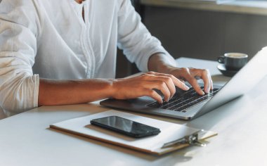 Kapalı kadın elleri klavyede çalışırken ya da evde çalışırken dizüstü bilgisayarla yazı yazıyor. Eğitim ya da online çalışma. Uzak çalışma konseri
