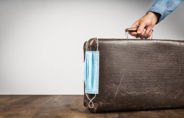 Erkek el retro eski bavul tıbbi maske yaratıcı güvenli seyahat konsepti kopyala