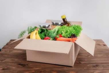 Ev mutfağında içi yiyecek dolu karton kutu açıldı. Güvenli teslimat konseri