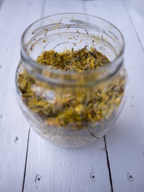 Öksürüğe karşı bitkisel şurup hazırlamak için taze tay çiçeği ve şeker dolu cam kavanoz.