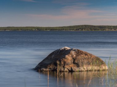 Büyük gri İsveç'te göle su dışına taşıyorsa kaya parçası