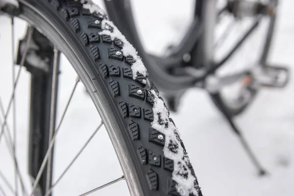 一辆冬季自行车轮胎在模糊背景下的螺柱特写 — 图库照片