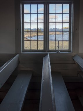 Beyaz duvarları ve şamdanlar içinde pencere eşiği ile Protestan bir şapel iç