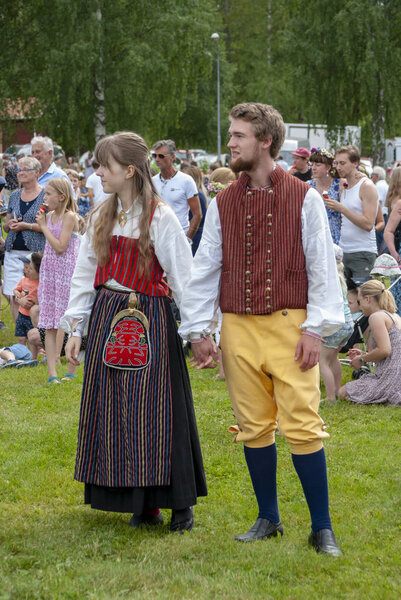 Пара в традиционном народном костюме от Jarvso (Halsingland, Швеция) и празднование летнего солнцестояния в Стенегард, Jarvso в 2016 году
