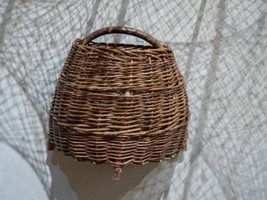 Duvarda relfecting balıkçılık ağları ile yuvarlak hasır sepet