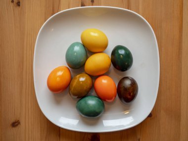 Colored eggs on a white plate, Colorful eggs on a white plate, Christmas decorations from colored eggs