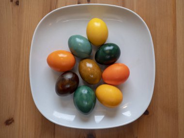 Colorful eggs on a white plate, Christmas decorations from colored eggs