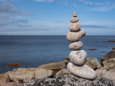 Bulanık arka planda deniz kıyısında kule veya çakıl piramidi