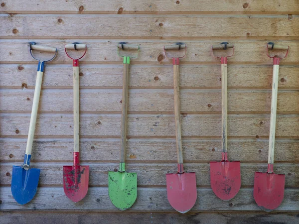 Bunte Spaten Hängen Einer Reihe Der Holzwand Stockfoto