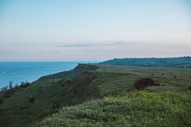 Yeşil çayırların panoramik manzarası ve uçurumdan gelen deniz, Ukrayna Mariupol